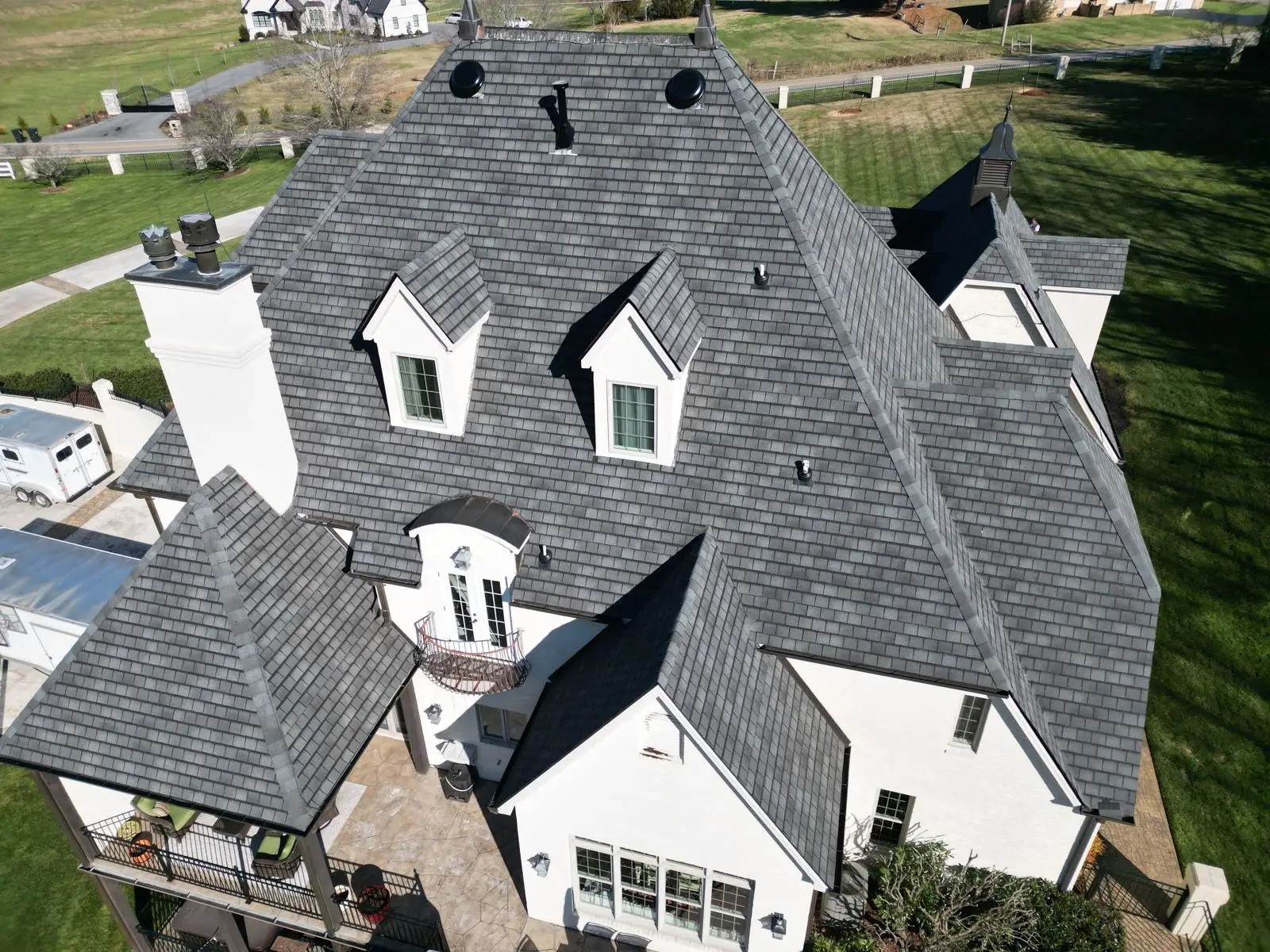 Aerial view of a steep, complex dormer roof completed by Whittington Construction