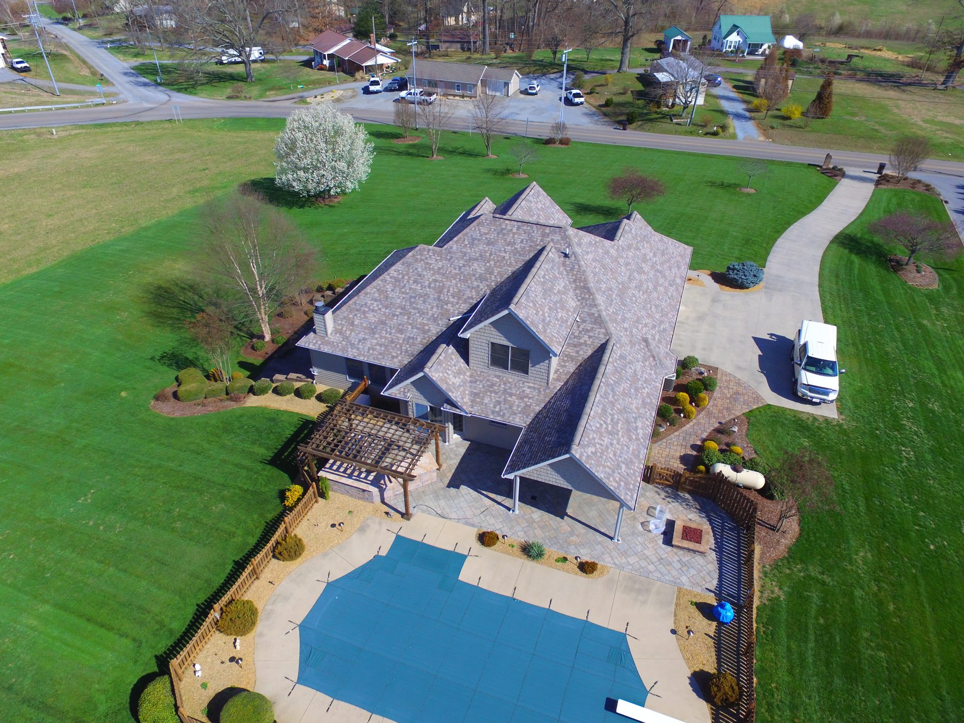 Drone view of a roof replacement on a large home with a pool in Piney Flats, TN